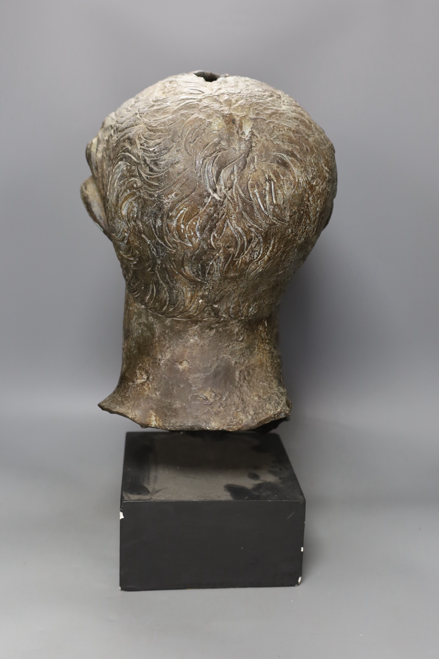 A bronze effect classical bust on stand, 54 cms high.